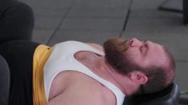 Büyük ve güçlü halterci, spor salonundaki simülatörde bacakları çalıştırır..