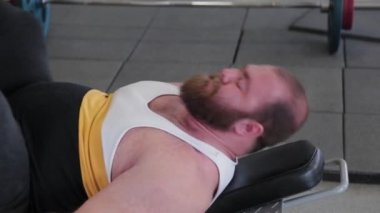 Büyük ve güçlü halterci, spor salonundaki simülatörde bacakları çalıştırır..