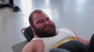 Büyük ve güçlü halterci, spor salonundaki simülatörde bacakları çalıştırır..