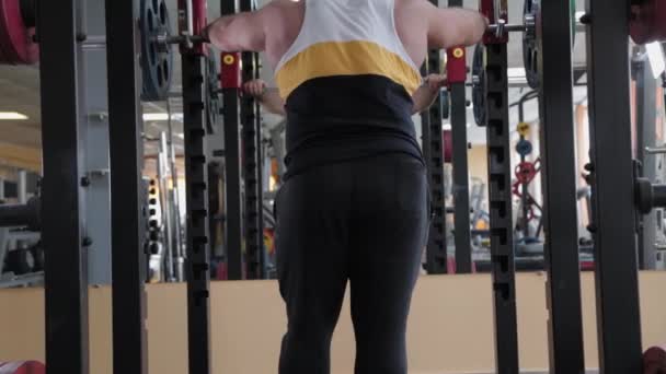 Großer und kräftiger Gewichtheber kauert mit schwerer Langhantel. — Stockvideo