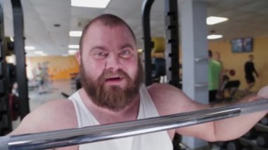 Büyük ve güçlü bir halterci egzersiz yapmadan önce halteri öfkeyle ısırır..