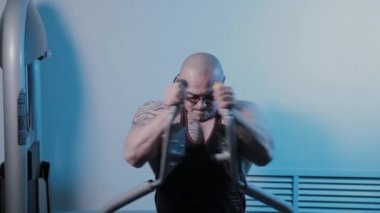 Profesyonel vücut geliştirici bir spor kulübünde simülatörde göğüs kaslarını çalıştırır..