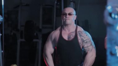 Profesyonel vücut geliştirici spor kulübünde halteri çenesine kaldırma egzersizi yapar..