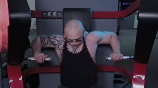 Bodybuilder professionnel entraîne les muscles pectoraux sur le simulateur dans un club de sport . — Video