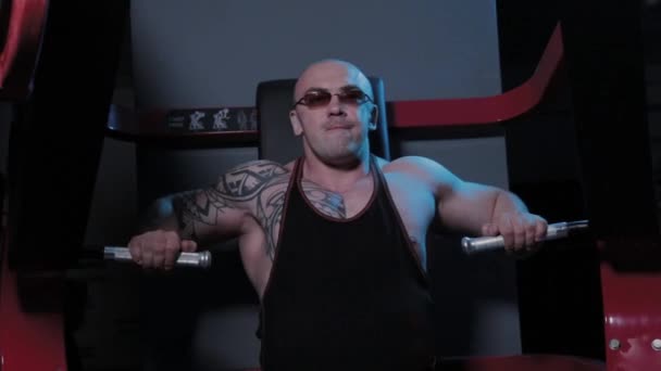 Profesionální kulturista trénuje prsní svaly na simulátoru ve sportovním klubu. — Stock video