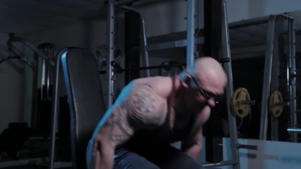 Επαγγελματίας bodybuilder σηκώνει αλτήρες πάνω από το κεφάλι του σε ένα αθλητικό σύλλογο. — Αρχείο Βίντεο