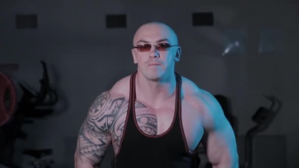 Bodybuilder professionnel faisant haltères monte sur le côté dans un club de sport . — Video