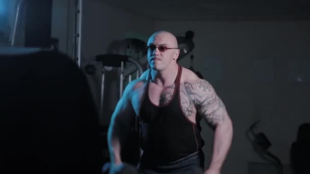 Bodybuilder professionnel faisant haltères monte sur le côté dans un club de sport . — Video