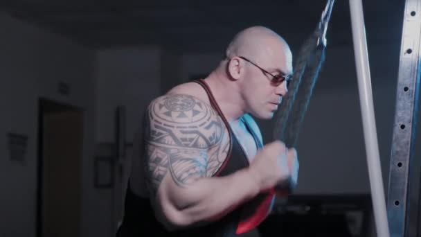 Bodybuilder professionnel forme des triceps sur un simulateur de bloc dans un club de sport . — Video