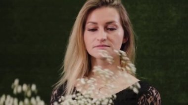 Çiçekçi makasla buket yapmak için çiçek saplarını kesiyor..