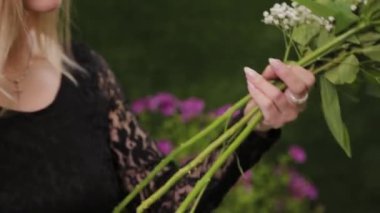 Çiçekçi makasla buket yapmak için çiçek saplarını kesiyor..