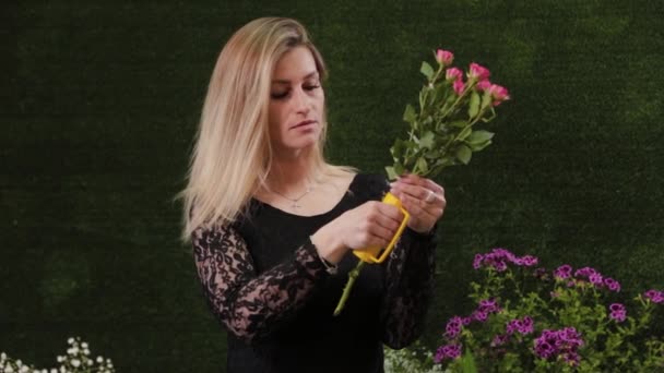 Florista rasga agulhas de uma rosa com uma ferramenta especial . — Vídeo de Stock