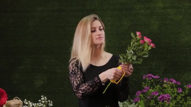 Fleuriste déchire aiguilles d'une rose avec un outil spécial . — Video