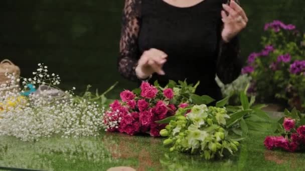 Флорист собирает цветы для букета . — стоковое видео