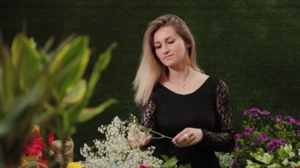 Ανθοπωλείο κόβει βλαστούς λουλουδιών για ένα μπουκέτο με ψαλίδι. — Αρχείο Βίντεο