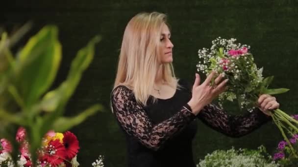 Η Ανθοπώλης κρατάει λουλούδια στα χέρια της. Όμορφα λουλούδια. — Αρχείο Βίντεο