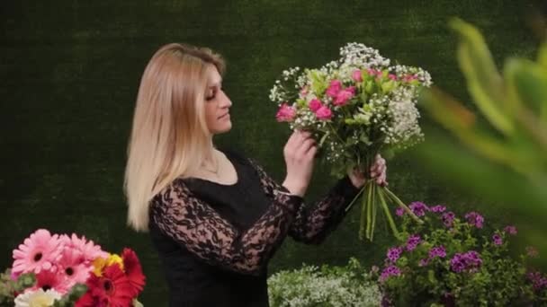 Florista sostiene un ramo en sus manos . — Vídeo de stock