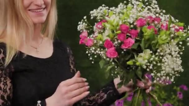 Florista sostiene un ramo en sus manos . — Vídeos de Stock