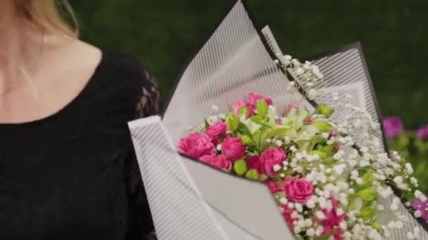 Fleuriste emballe un bouquet de fleurs dans un beau papier . — Video