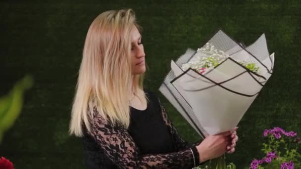 Florista detém um buquê em suas mãos . — Vídeo de Stock