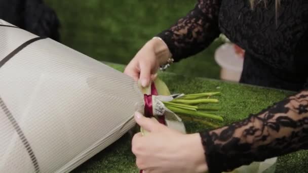Bloemist bindt een boeket met mooie linten. — Stockvideo