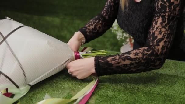 Fleuriste attache un bouquet avec de beaux rubans . — Video