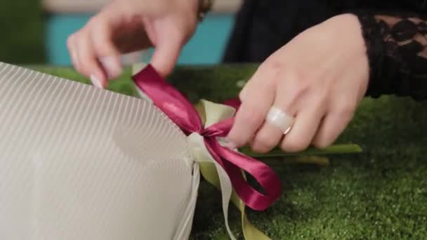 Fleuriste attache un bouquet avec de beaux rubans . — Video