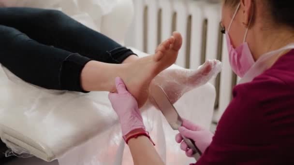 Pedicure meester reinigt de benen van een vrouw. — Stockvideo