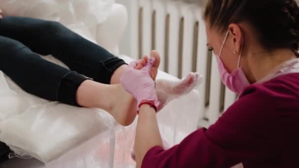 Pedicure mestre limpa as pernas de uma mulher . — Vídeo de Stock