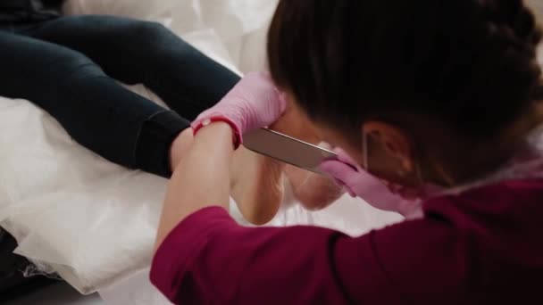 Pedicure meester reinigt de benen van een vrouw. — Stockvideo