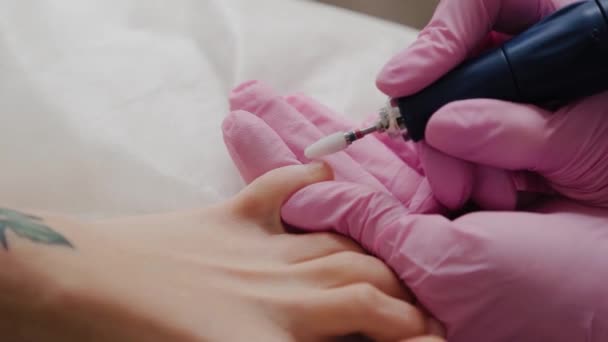 Pedicure meester zagen teennagels van een vrouw. — Stockvideo