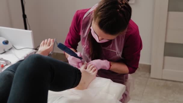 Pediküre-Meister sägt Fußnägel einer Frau. — Stockvideo