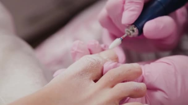 Pedicure meester zagen teennagels van een vrouw. — Stockvideo