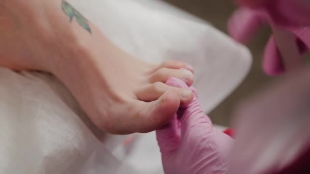 Pedicure mestre corta uma mulher unhas dos pés . — Vídeo de Stock