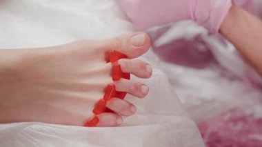 Pedikür ustası kadın tırnaklarını parlatır..