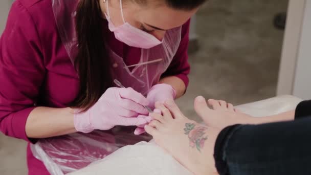 Pedikúra mistr řeže kůžičky na ženské noze. — Stock video