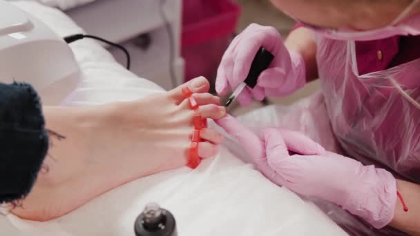 Pedicure mistrz poleruje kobietom paznokcie u nóg. — Wideo stockowe