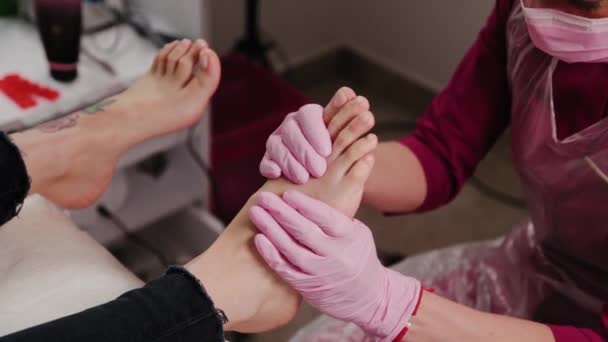 Pedicure mestre faz uma massagem nos pés para uma mulher. — Vídeo de Stock