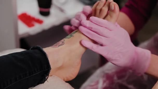 Maestro di pedicure fa un massaggio ai piedi a una donna. — Video Stock