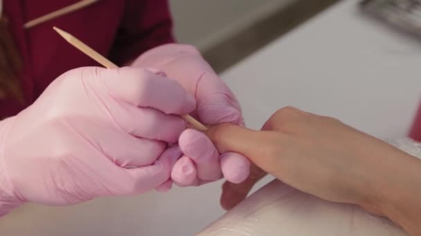 Manicurista levanta cutículas con una herramienta especial . — Vídeos de Stock