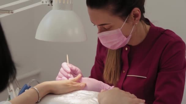 Manicurista solleva cuticole con uno strumento speciale. — Video Stock