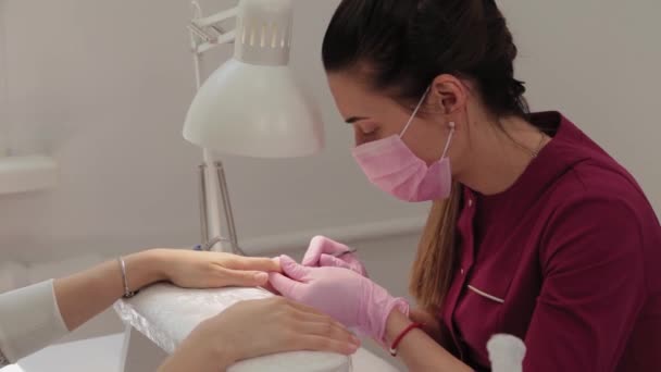 Manicurista solleva cuticole con uno strumento speciale. — Video Stock