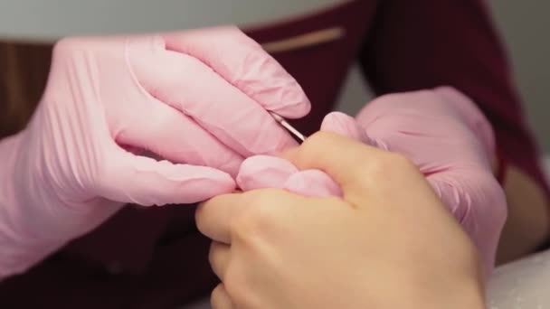 Manicure verhoogt nagelriemen met een speciaal gereedschap. — Stockvideo