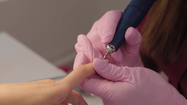 Manikiurzystka tnie paznokcie maszyną do klienta w salonie manicure. — Wideo stockowe