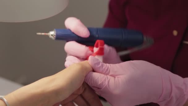 Manikiurzystka tnie paznokcie maszyną do klienta w salonie manicure. — Wideo stockowe