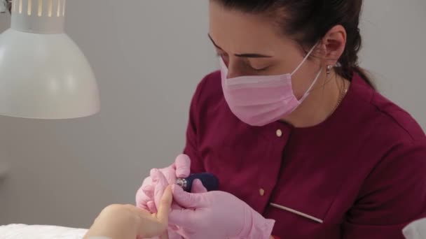 Manicure corta pregos com uma máquina para um cliente em um salão de manicure . — Vídeo de Stock