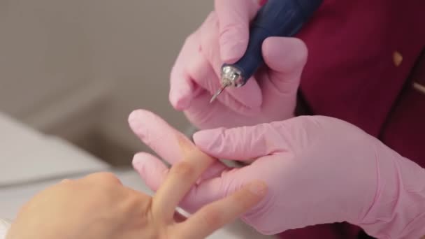 La manicura corta clavos con una máquina a un cliente en un salón de manicura . — Vídeo de stock