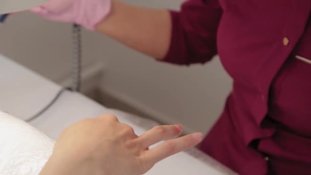 La manicura corta clavos con una máquina a un cliente en un salón de manicura . — Vídeos de Stock