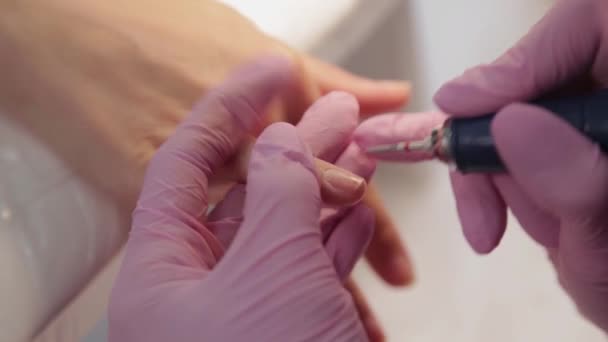 Manicurist cuts nails with a machine to a client in a manicure salon. — Stock Video
