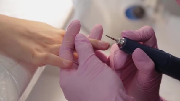 Manikérka stříhá nehty strojem klientovi v manikúře. — Stock video